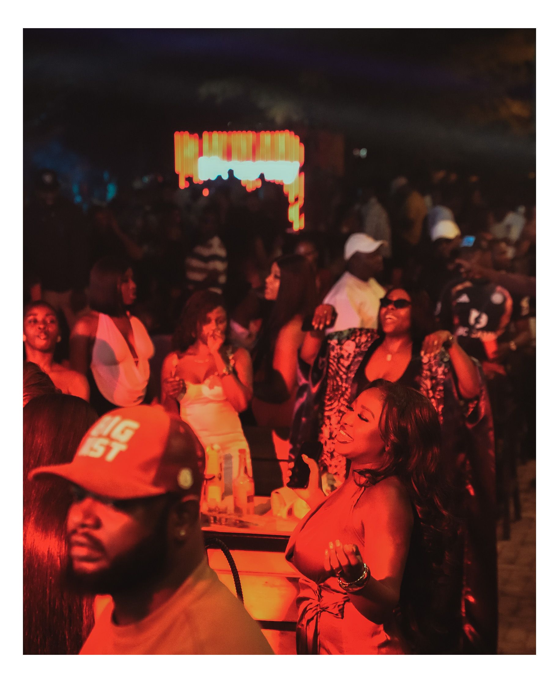 Crowd bathed in red light dancing at Romie's Block