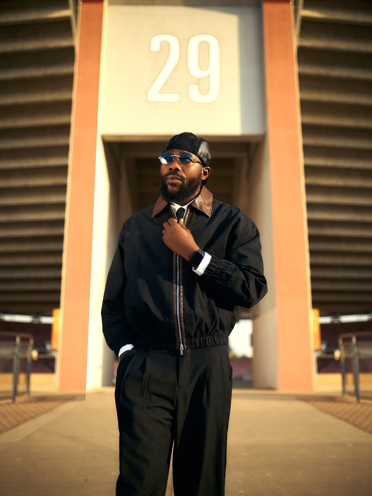 DJ Romie standing beneath a stadium archway numbered 29